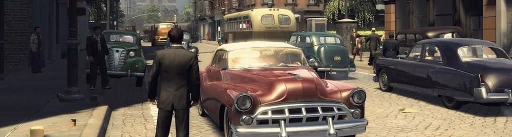 The Complete Mafia Game Story Timeline Explained | 1920 - 1968 4 A street scene from Mafia 2 featuring Vito Scaletta in a pinstripe suit standing in front of a vintage red car. The 1950s-era city of Empire Bay is bustling with pedestrians, classic cars, and a yellow city bus in the background, evoking a mid-century urban vibe filled with post-war style and mafia undertones.